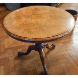 A walnut circular tilt-top table on turned baluster support and cabriole legs