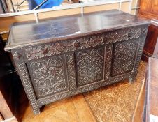 An 18th century carved oak coffer with two plank top and moulded edge,