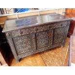 An 18th century carved oak coffer with two plank top and moulded edge,