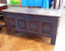 An 18th century oak coffer with three panel top, carved fluted frieze and foliate panelled front,