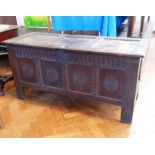 An 18th century oak coffer with three panel top, carved fluted frieze and foliate panelled front,