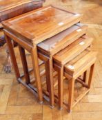 A nest of four Chinese hardwood occasional tables with raised borders on square legs,