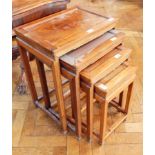 A nest of four Chinese hardwood occasional tables with raised borders on square legs,