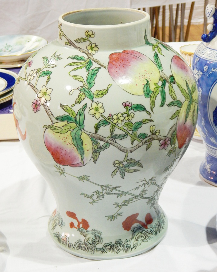 A porcelain vase with painted decoration of peaches on a peach tree, with a bat,