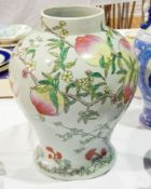 A porcelain vase with painted decoration of peaches on a peach tree, with a bat,