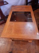 A 20th century oak coffee table with glazed central piece,