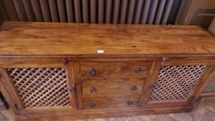 A modern hardwood sideboard with three short drawers flanked by open latticework cupboards