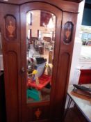 An Edwardian mahogany single wardrobe with dentil frieze, mirror plate door enclosing hanging shelf,