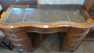 A mahogany serpentine front pedestal desk, with inset writing surface,