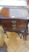 A mahogany veneer dropflap dining table with three short drawers on cabriole legs,