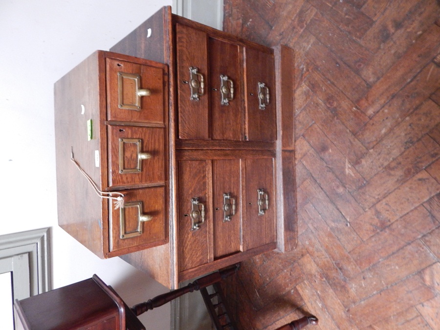 An oak filing cabinet with three short drawers,