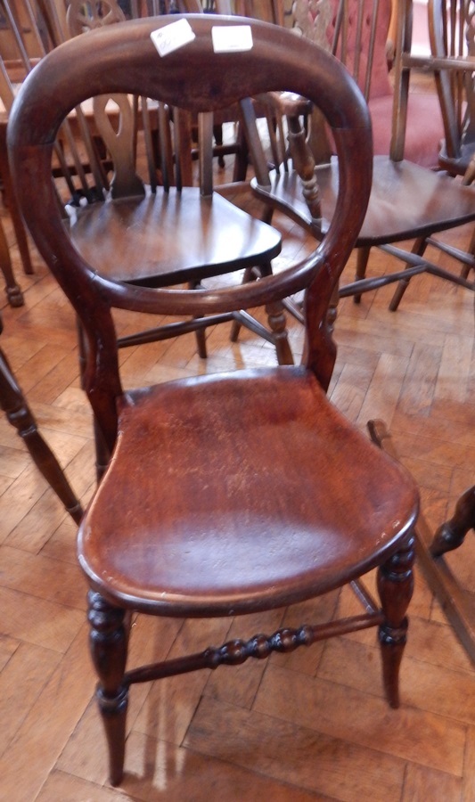 A Victorian balloon back chair on turned bobbin supports