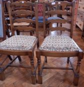 Two ladderback chairs with floral decorated seats and a Lloyd Loom style chair