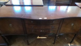 A mahogany reproduction serpentine front sideboard, with three central drawers,