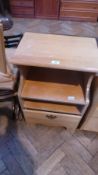 A modern pale wood bedside cupboard with open shelf and drawer below,