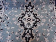 A wool runner with turquoise ground, white guard, floral decoration,