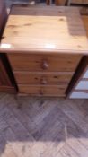 A modern pine bedside chest of three short drawers,