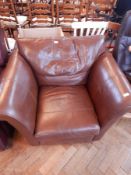 A brown leather armchair on square feet