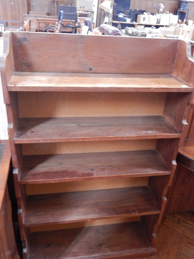 An old pine open bookcases of five shelves on a plinth base,