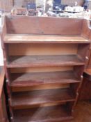 An old pine open bookcases of five shelves on a plinth base,