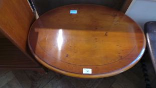 A yewwood veneer oval top coffee table on turned legs with undershelf,