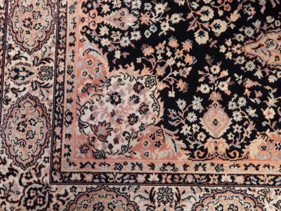 A Persian rug with floral decoration, on blue ground with white and blue fences and white guard,
