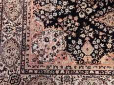 A Persian rug with floral decoration, on blue ground with white and blue fences and white guard,