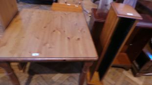 A modern pine square top dining table with moulded edge on turned legs,