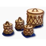 Four pottery cake boxes by Rachel Kneebone, the larger box cylindrical, the lid with arched handle,