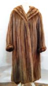 A full-length mink coat with shawl collar, turned-up sleeves, the lining in shreds,