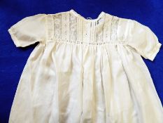A silk christening gown trimmed with lace, another silk christening gown trimmed with lace,