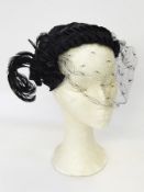 A 1950's black satin hat by Ruby Cook, Toronto, trimmed with a feather and black net,