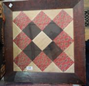 A framed piece of patchwork, possibly American, paisley, black and cream squares,