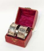 A pair silver napkin rings, scroll engraved,