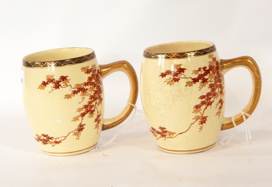 A pair of Japanese pottery barrel shaped mugs decorated in red and gilt with maple leaf branches