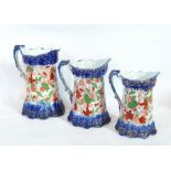 A pottery character jug of an admiral and three graduated jugs with blue base and top with red and