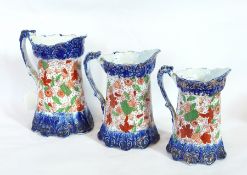 A pottery character jug of an admiral and three graduated jugs with blue base and top with red and