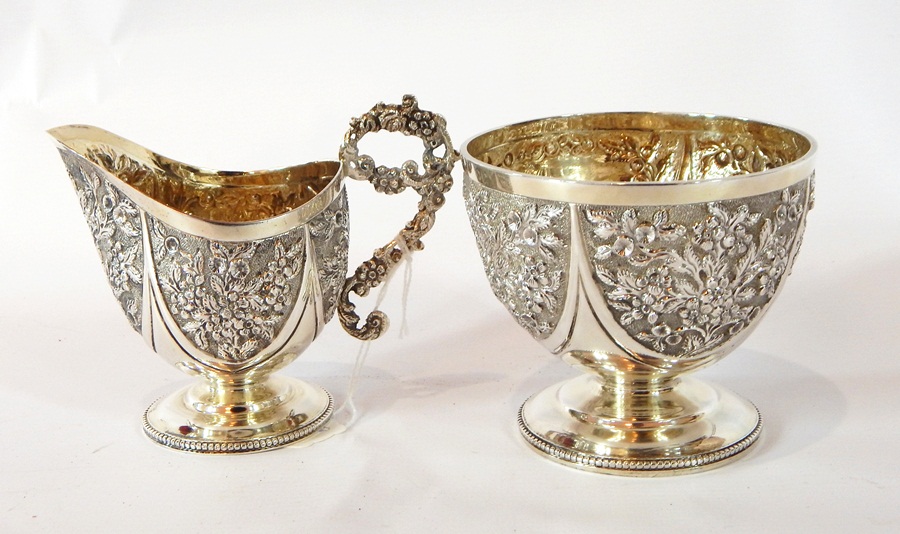 A Victorian silver sugar bowl with heavy floral repousse pattern,
