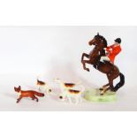 A Beswick huntsman on a rearing horse with three hounds,