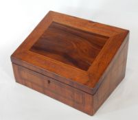 A 19th century yewwood stationery box with sloping top opening to reveal a fitted interior for