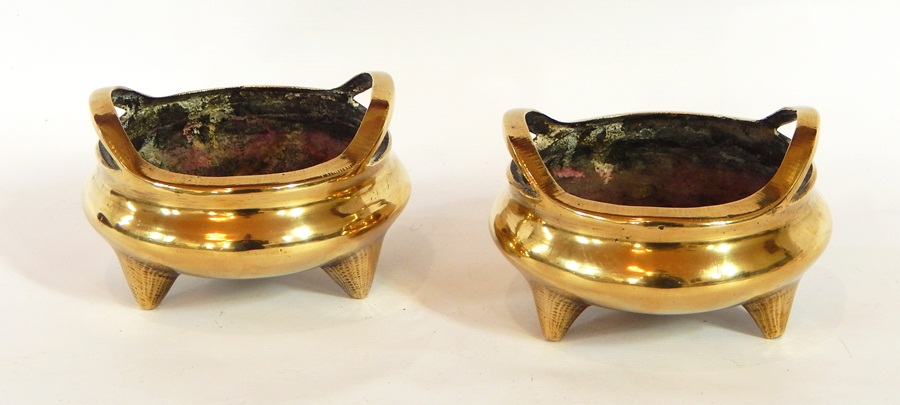 A pair of Chinese bronze shallow two handled censers, possibly Xuande,