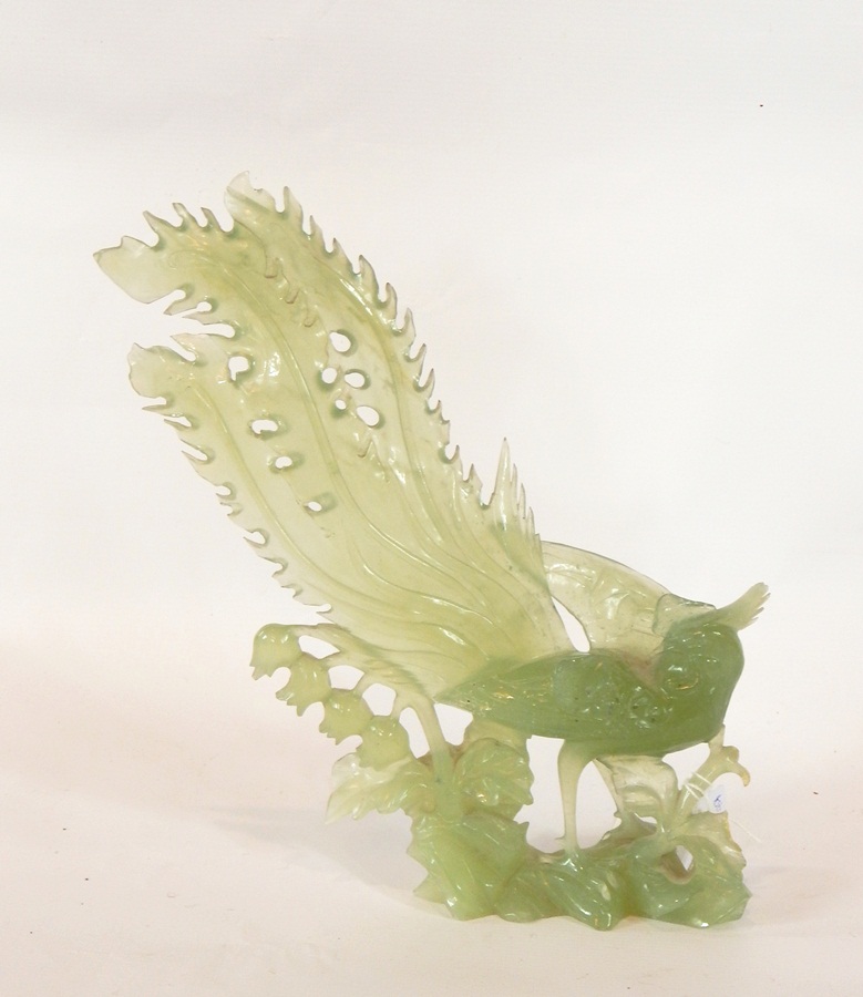 20th century carved jade model of a pheasant/peacock standing on rocky outcrop among foliage,