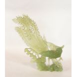 20th century carved jade model of a pheasant/peacock standing on rocky outcrop among foliage,