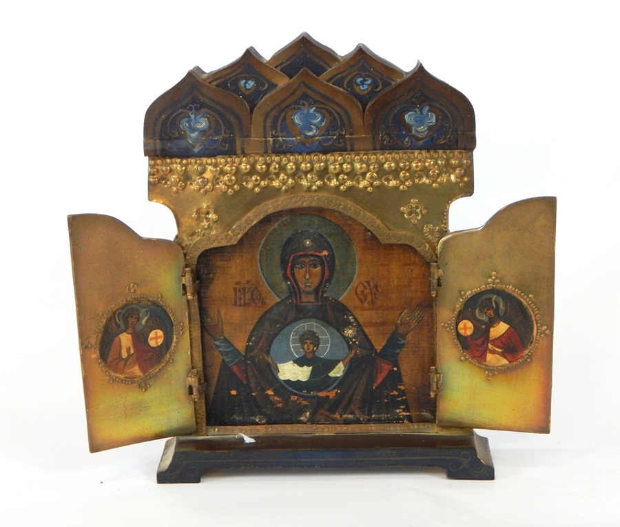 A Polish brass and painted icon, enclosed in a travelling stand with a pair of hinged doors,