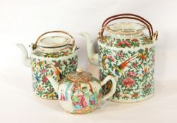 A Chinese famille rose bullet shaped teapot and a graduated pair of cylindrical teapots with