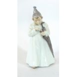 A Royal Copenhagen porcelain figure of a child in a long white robe, umbrella and hat, No.