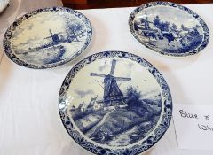 Three Delft chargers depicting a printed windmill and workers, 39cm wide,