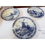 Three Delft chargers depicting a printed windmill and workers, 39cm wide,