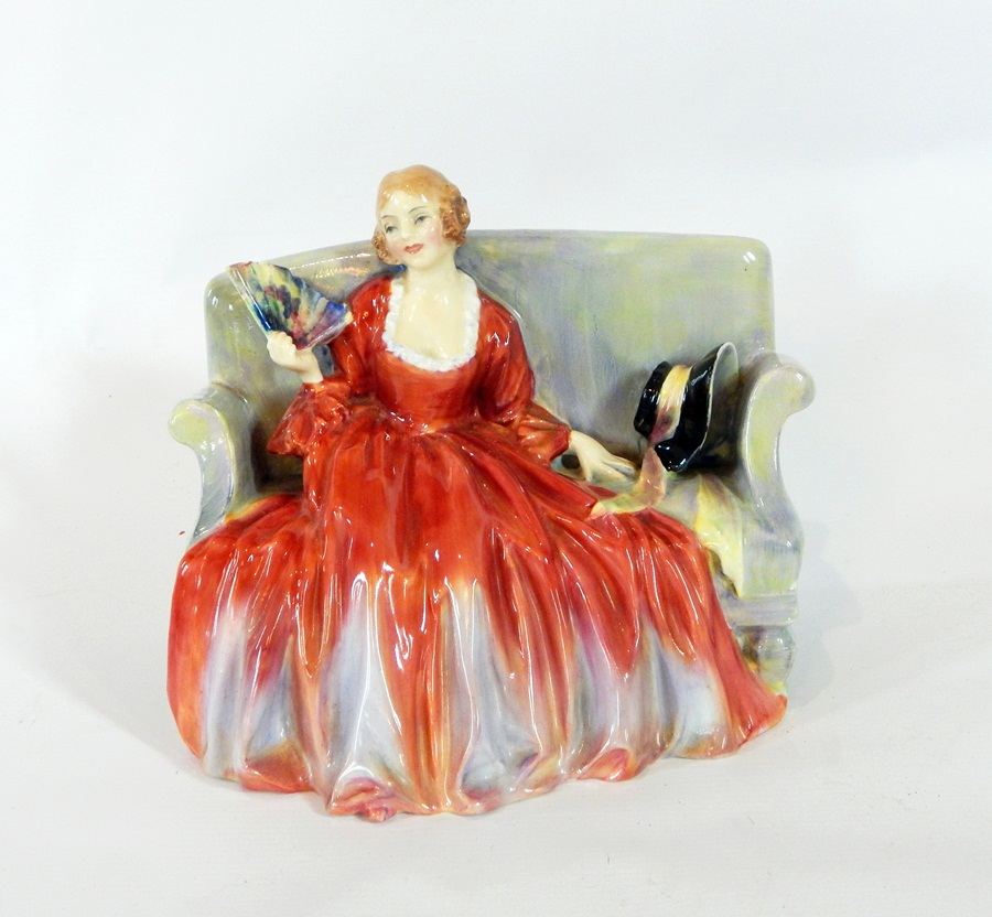 A Royal Doulton porcelain figure 'Sweet and Twenty', of a lady seated on a sofa in formal dress,