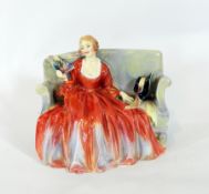 A Royal Doulton porcelain figure 'Sweet and Twenty', of a lady seated on a sofa in formal dress,